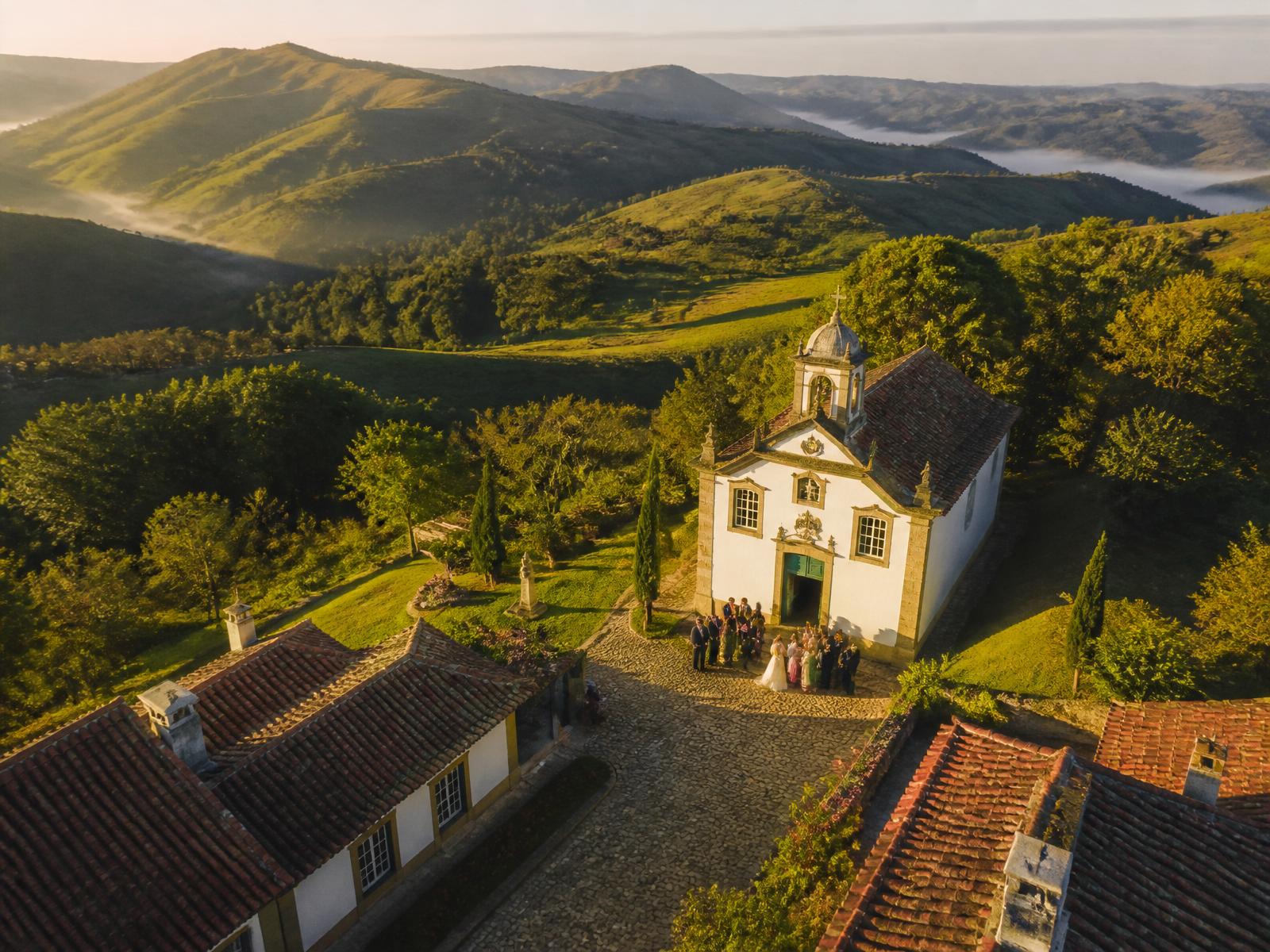 Vista aérea de fazenda histórica em Minas Gerais com capela colonial e montanhas ao fundo — cenário para casamento no campo