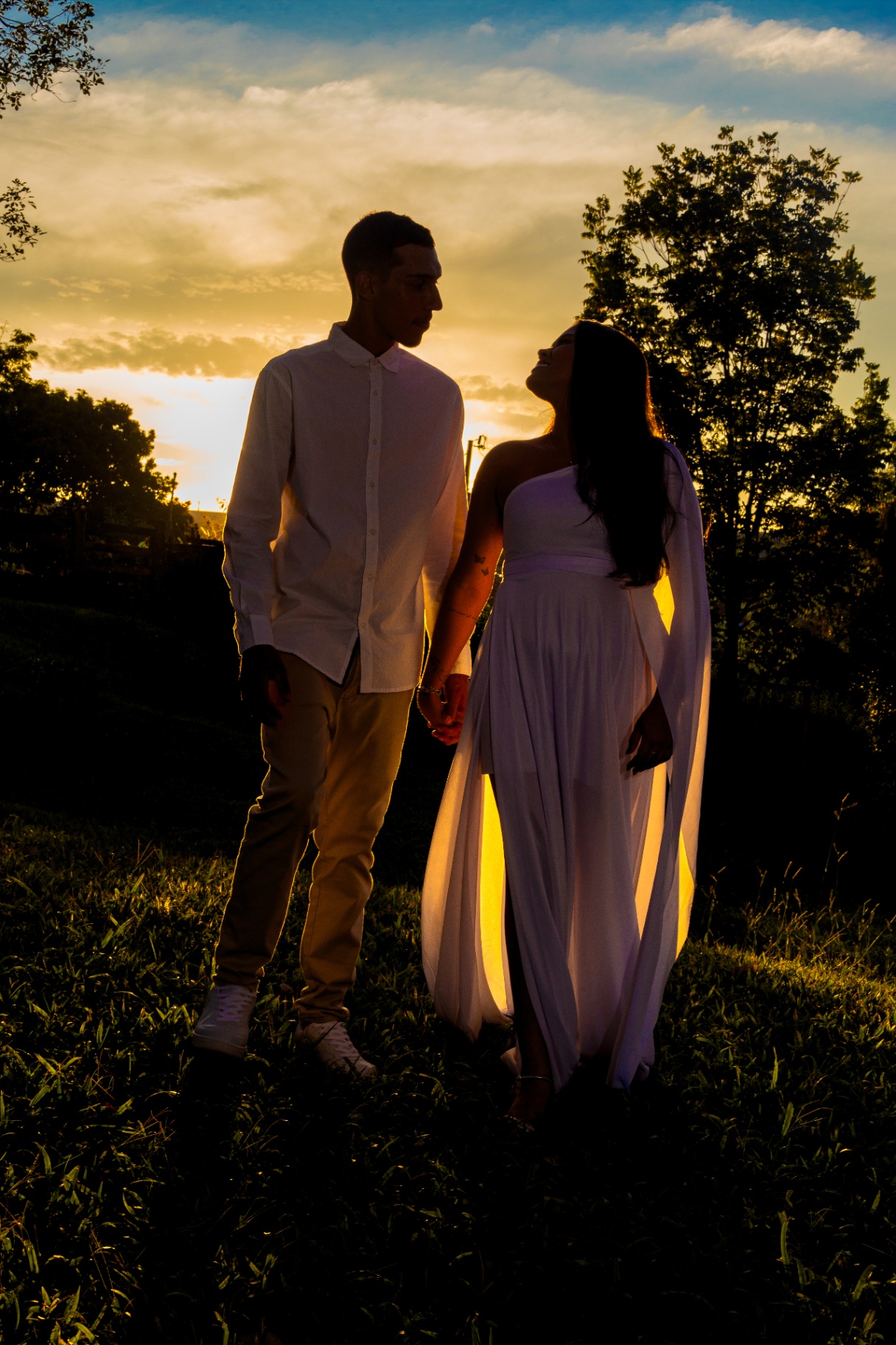 Silhueta do casal contra o pôr do sol dourado