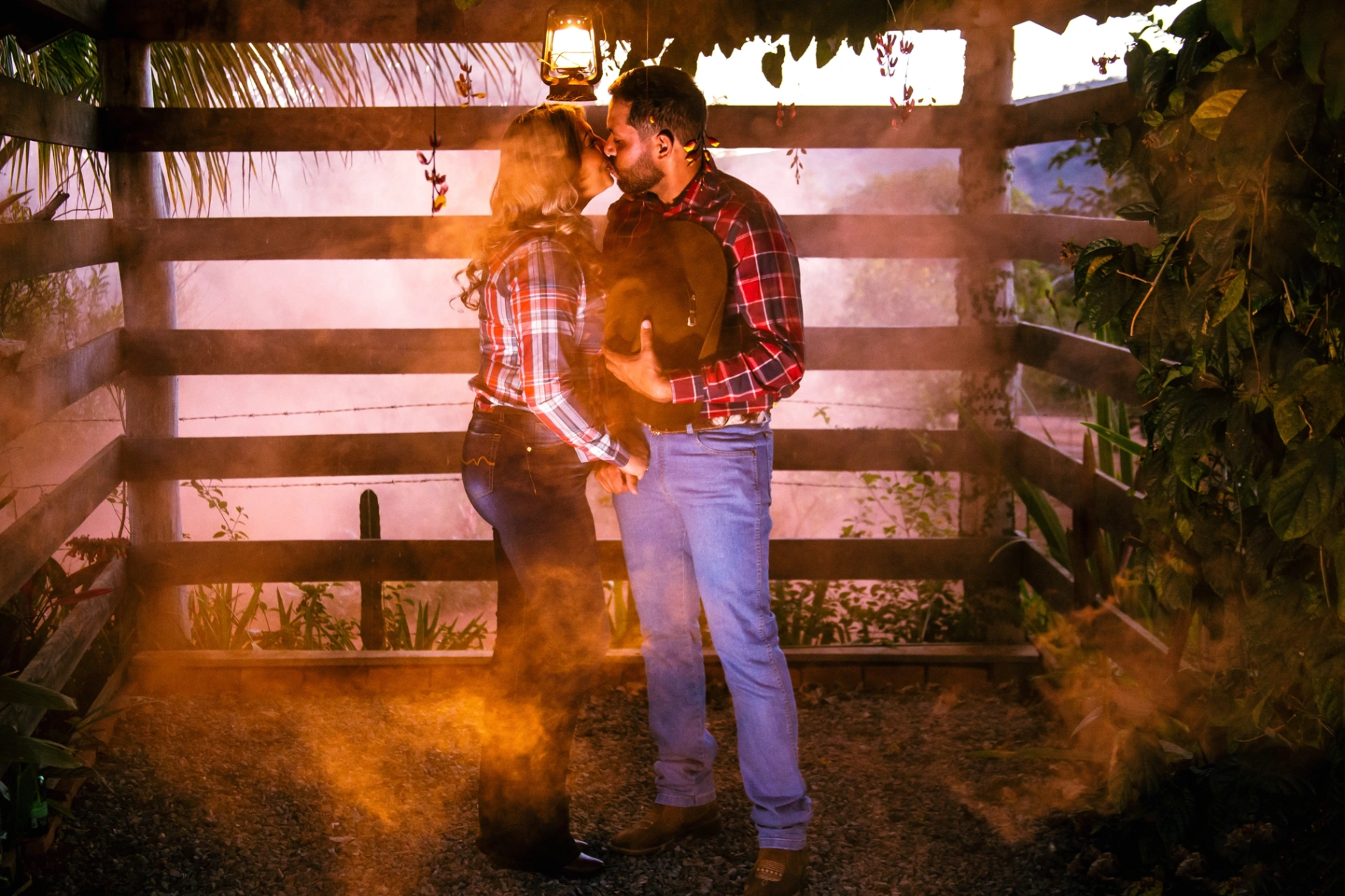 Vanilda e Júlio se beijando sob lampião em cena country com fumaça dourada